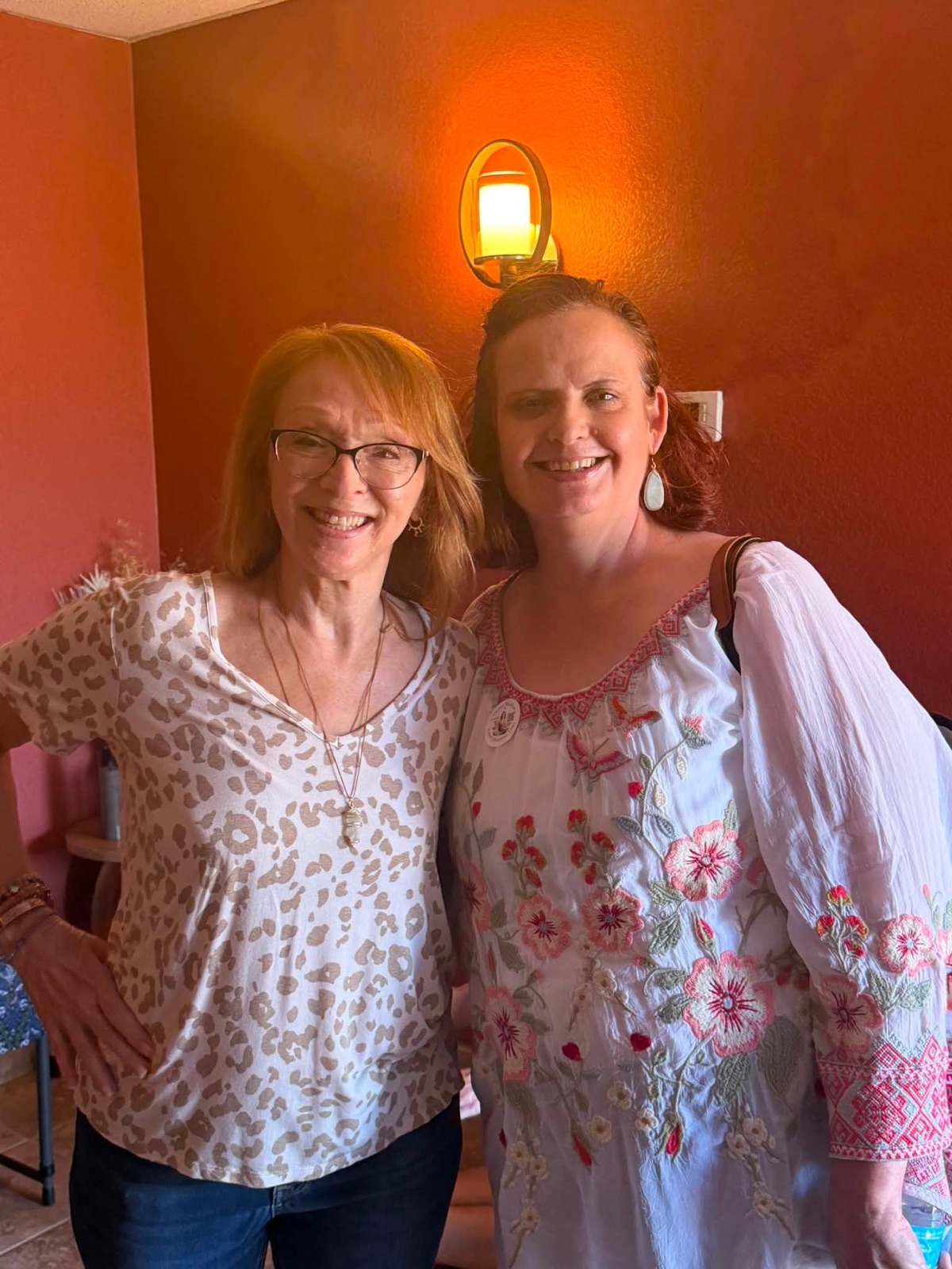Two smiling people posing together inside the yoga studio.